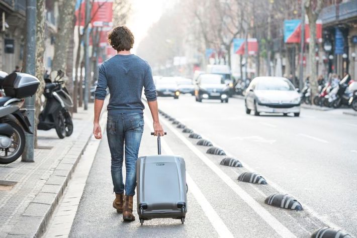 Man som går med en epic resväska